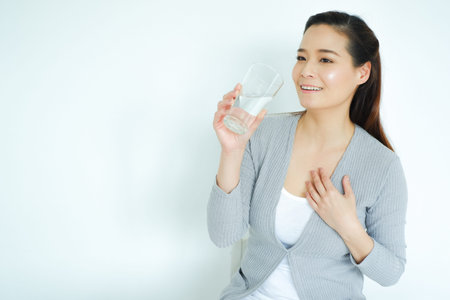 Asia woman drinking water on tableの写真素材