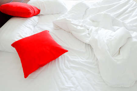 pillow on messy and sheet bed in bedroomの写真素材