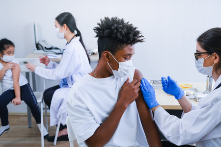 Professional nurse giving flu or antiviral vaccine to people in hospital or clinic or or health centerの写真素材