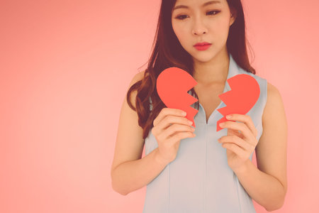 Portrait beautiful asian woman on pink background, unhappy in valentine day concept, model is...