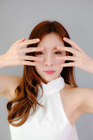 Portrait beautiful asian woman on gray background, emotions actionの写真素材