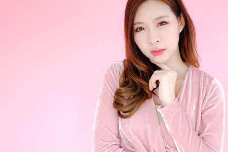 posing beautiful asia woman on pink background, emotions action, fashion setの写真素材