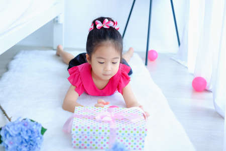 Little cute asia girl with gift box or presentの写真素材