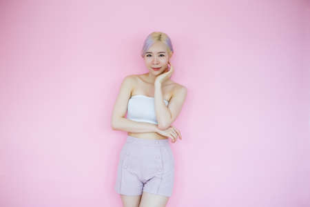 posing beautiful asian woman posing on pink background, emotions action, beauty conceptの写真素材