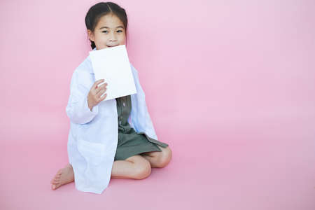 Portrait beautiful cute asian child girl on pink background with red heart sign wear Lab setの写真素材