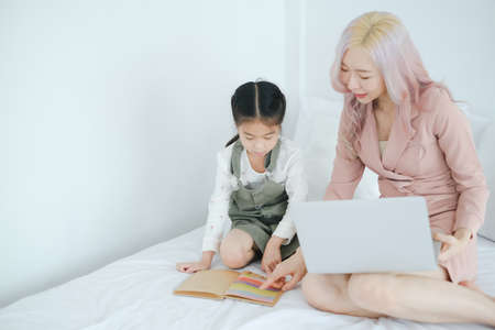 Asian little cut girl learning home school with woman teacherの写真素材