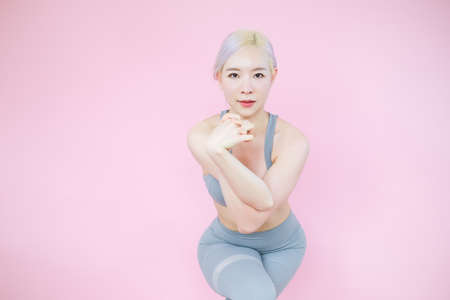 beautiful asian woman on pink background, fitness sports and recreation conceptの写真素材