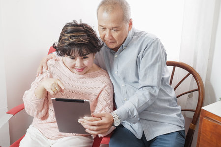 Portrait asian senior woman and old man, couple elder happy at home playing social network or social...