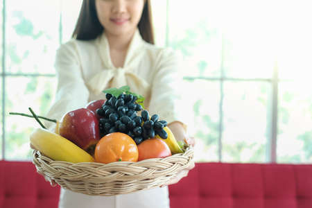 Professional nutritionist asian woman holding fresh fruit in clinic roomの写真素材