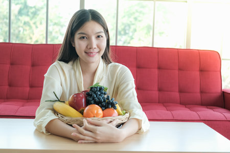 Professional nutritionist asian woman holding fresh fruit in clinic roomの写真素材