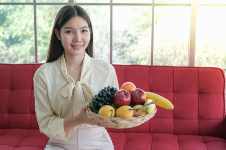 Professional nutritionist asian woman holding fresh fruit in clinic roomの写真素材