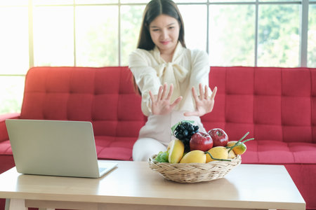 Professional nutritionist asian woman holding fresh fruit in clinic roomの写真素材