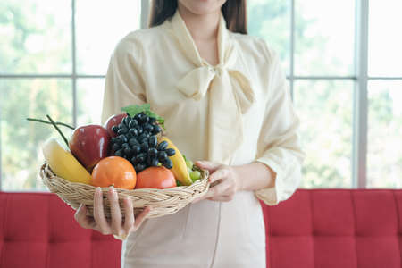 Professional nutritionist asian woman holding fresh fruit in clinic roomの写真素材