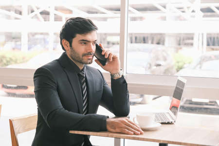 business caucasian man sitting in working in co working space near windowの写真素材