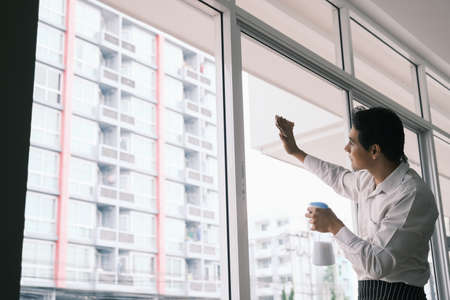 Asian man worker and cleaning glass windowの写真素材