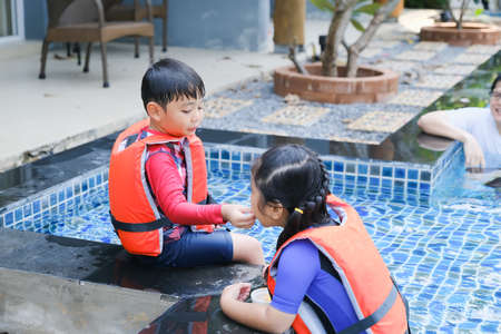 happy asian little kids playing in swimming poolの写真素材