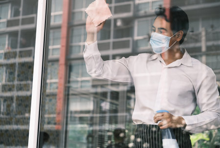 Asian man worker and cleaning glass window