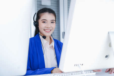 beautiful asian woman working call center operator with headset in office or workplaceの写真素材