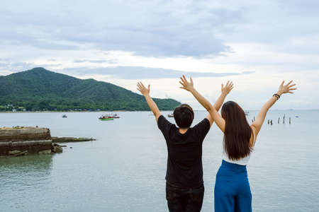 back view of two asia women having fun together on seasideの写真素材