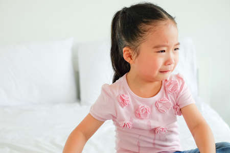 crying asian little girl being consoled by single momの写真素材