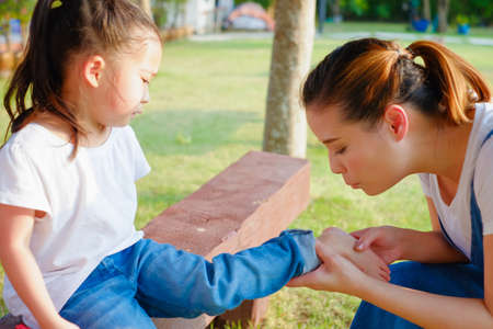 Family take care small child girl naughty in park until her have lesion on the feetの写真素材