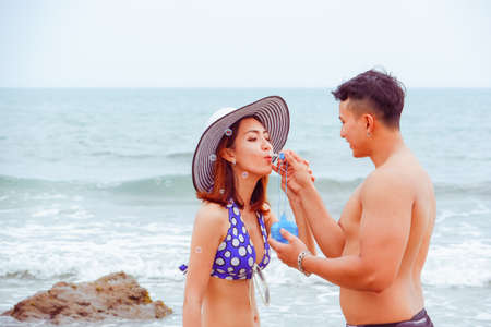 Portrait asian couple in love, sexy bikini on the beach, happy life on summer seasonの写真素材