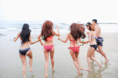 Abstract Blurred sexy bikini asian women wearing swimwear playing with friends in seaside on the beachの写真素材