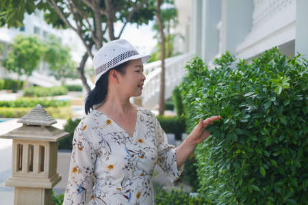 portrait senior asian woman wear a hat in gardenの写真素材
