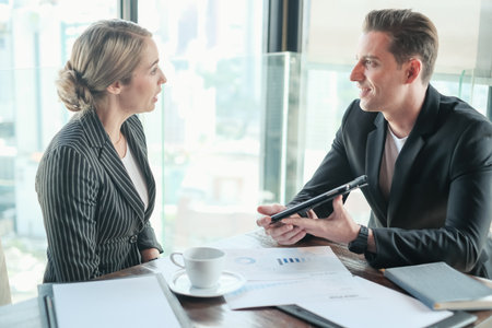 Two businessman and businesswoman couple meeting in co working space at sky lounge or officeの写真素材