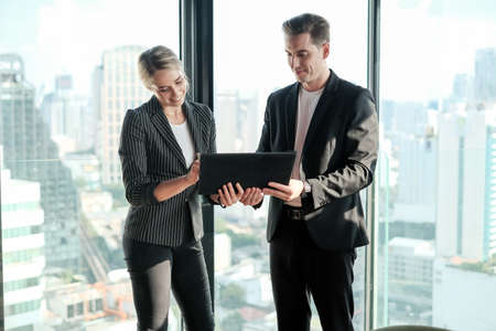 Two businessman and businesswoman couple meeting in co working space at sky lounge or officeの写真素材