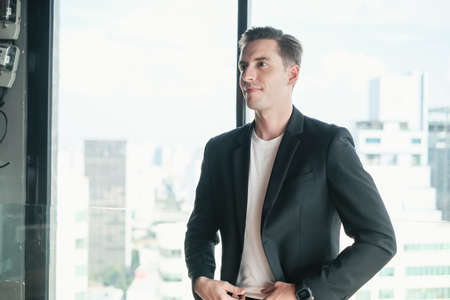 portrait business caucasian man standing in office room near windowの写真素材