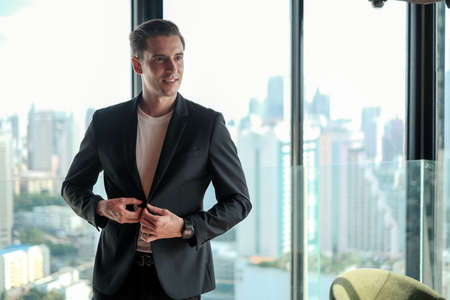 portrait business caucasian man standing in office room near windowの写真素材