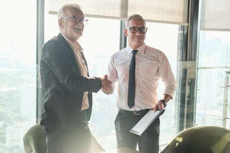 Two Senior businessman couple meeting in co working space at skyscraper lounge or officeの写真素材