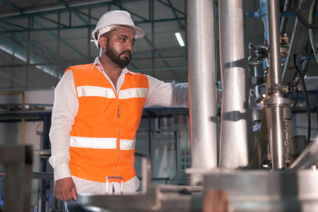 portrait Asian male factory worker or man engineer or expert staff wear safety vest and helmet of maintenance and checking steam boilerの写真素材