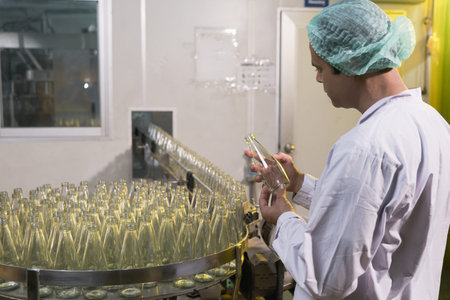 South Asia senior male factory worker or expert quality staff is checking bottles line for beverage