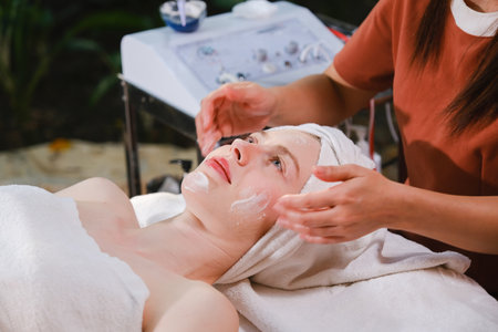 Close up of a young woman having a facial massage at the spaの写真素材