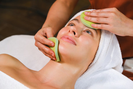 Close-up of a woman receiving a facial massage at spa centreの写真素材