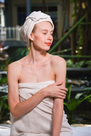 Portrait of young woman with towel on her head relaxing at spaの写真素材