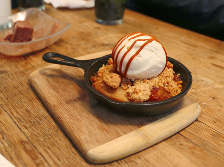 Vanila ice cream top on roasted peach crumble cakeの写真素材