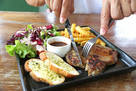 Pork chop steak with potato fried, vegetable and pepper sauce