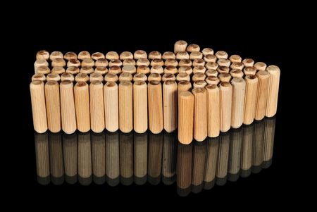 Wooden arrow on glass with reflection isolated on black.の写真素材