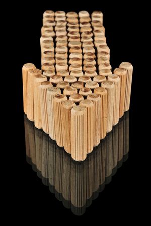 Wooden arrow on glass with reflection isolated on black.の写真素材