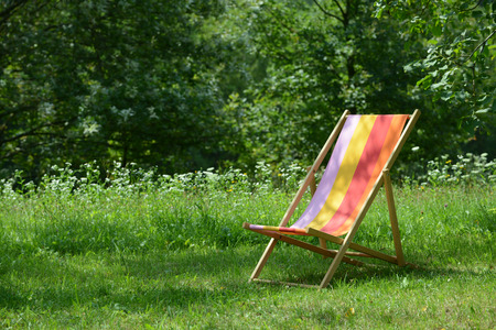 Wooden deckchair standing on the green in summer.の写真素材