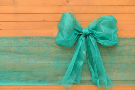 Big green ribbon on wood. Used as background, space for text.の写真素材