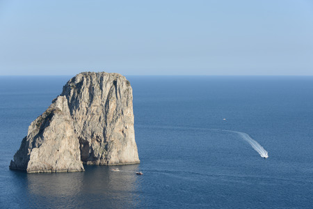 Faraglioni rocks at Capri island in Italy with ships.の写真素材