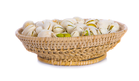 Pistachio nuts in basket on white backgroundの写真素材