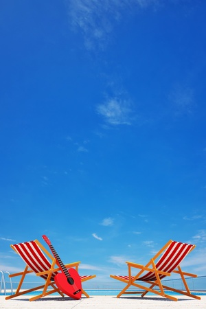 swimming pool with 2 beach chairs   guitarの写真素材