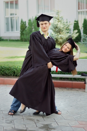 Graduates with a smile on the faces of dancing in the courtyard of the institutionの写真素材