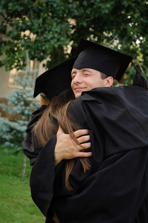 Graduate embraced the girl. He closed his eyes for joyの写真素材