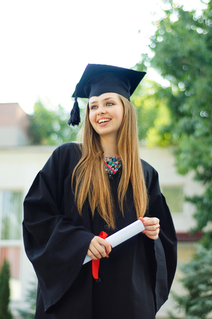 Student enjoys graduation. In her hands the diploma. Girl smilingの写真素材